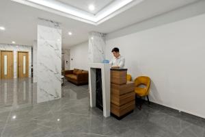 un hombre sentado en un mostrador en una habitación en 22housing Residence Suites en Hanói