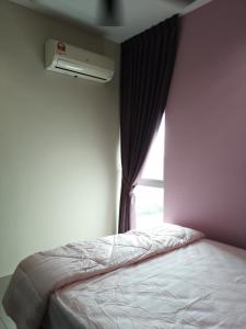 a bedroom with a bed and a window with a air conditioner at Metropol Suite in Bukit Mertajam