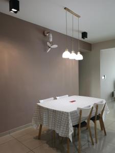 Metropol Suite في بوكيت ميرتاجام: غرفة طعام مع طاولة بيضاء وكراسي
