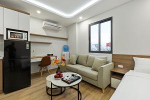 a room with a bed and a couch and a table at 22housing Residence Suites in Hanoi