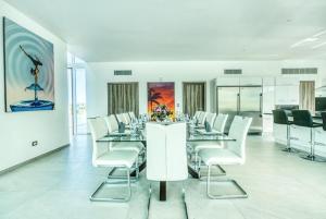 a dining room with white tables and white chairs at Las Palmas 16 Chef, Butler, Maid and Golf Cart in Punta Cana