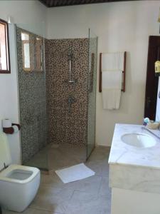 a bathroom with a shower and a toilet and a sink at Zanzibar Bahari Villas in Matemwe