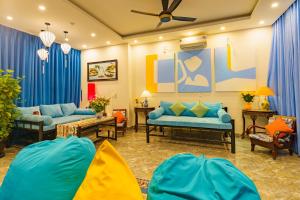 Elle comprend un salon doté d'un mobilier bleu et de rideaux bleus. dans l'établissement HA Mountain View Pool Villa, à Hội An