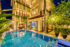 una piscina frente a un edificio en HA Mountain View Pool Villa, en Hoi An