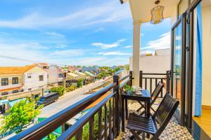 Un balcón con una mesa y vista a una calle. en HA Mountain View Pool Villa, en Hoi An