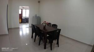 uma mesa de jantar com cadeiras pretas e um frigorífico em Anggerik Heights Homestay em Bentong