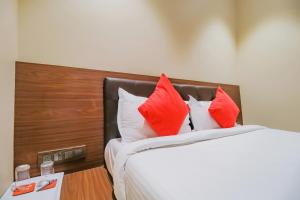 a bedroom with a bed with red and white pillows at Flagship 79617 Hotel Ahlan International in Mumbai