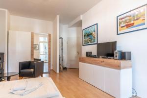 a living room with a flat screen tv and a desk at Villa Eden Binz Typ 2 / Apartment 3 in Binz