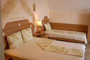 a bedroom with two beds and a lamp at Family hotel Tropicana in Ravda +34 photos
