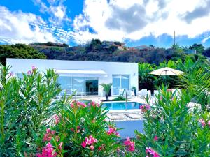 une maison blanche avec une piscine et des fleurs dans l'établissement Tajuya Suite, à Los Llanos de Aridane