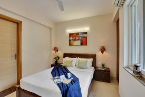 a hotel room with a bed and a window at Veeraas Calangute - 2BHK Apartment with Pool in Marmagao