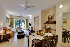 MarmagaoにあるVeeraas Calangute - 2BHK Apartment with Poolのリビングルーム(ダイニングテーブル付)、