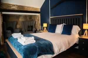 a bedroom with a large bed with blue walls at The George & Dragon Country Inn in Seaton