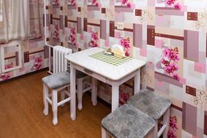 une table et deux chaises dans une pièce avec papier peint rose et violet dans l'établissement Лас-Вегас, à Petropavlovsk-Kamtchatski