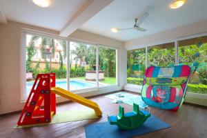 uma sala para crianças com um baloiço e um parque infantil em Veeraas Calangute - 2BHK Apartment with Pool em Marmagao