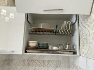a white cabinet with plates and dishes in it at Lovely house in the city center in Bishkek