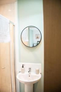 baño con lavabo y espejo en la pared en The George & Dragon Country Inn, en Seaton