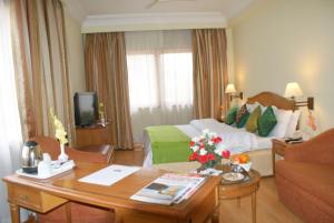 a hotel room with a bed and a table in a room at Ritz Plaza in Amritsar