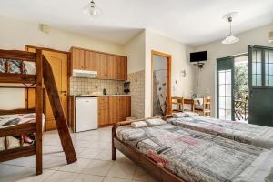 a bedroom with two bunk beds and a kitchen at Daratos studio 5 in Kefallonia