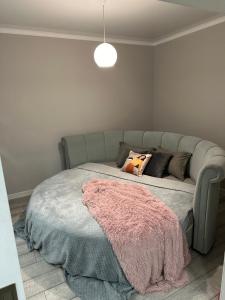 - une chambre avec un lit et une couverture rose dans l'établissement Latifa Residence, à Almaty