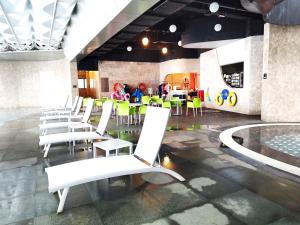 a group of white chairs in a room with a table at Genting SmokyStayCationHut AT Ion Delemen in Genting Highlands