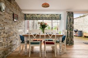 a dining room with a table and chairs at Cossington Park Cottage in Cossington