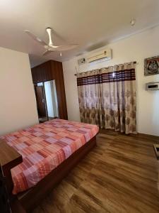 a bedroom with a bed and a ceiling fan at Laasya Vilaasa in Mangalore
