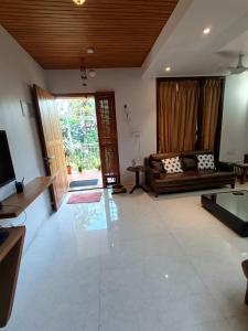 a living room with a couch and a television at Laasya Vilaasa in Mangalore