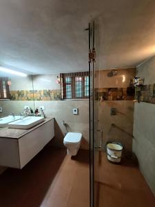 y baño con aseo, lavabo y ducha. en Laasya Vilaasa, en Mangalore