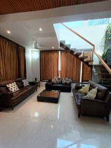 a living room with couches and a staircase at Laasya Vilaasa in Mangalore