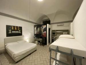 a room with two beds and a desk and a tv at Borghese Palace Art Hotel in Florence