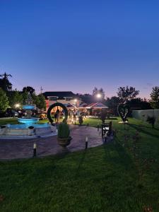 a night view of a park with a fountain at Poiana Verde Garden House in Poiana Campina
