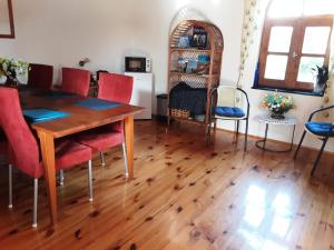 a dining room with a wooden table and red chairs at Herberg Tisza in Tiszabábolna +28 photos