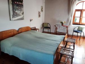 una camera da letto con un letto con due sedie e un tavolo di Herberg Tisza a Tiszabábolna