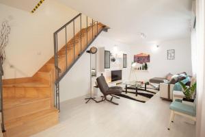 a living room with a staircase and a couch at Central duplex apartment+parking in Novi Sad