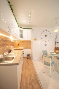 a kitchen with a sink and a table with a clock on the wall at Central duplex apartment+parking in Novi Sad