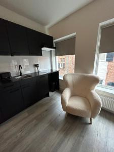 een woonkamer met een stoel en een keuken bij The Residence Deventer in Deventer