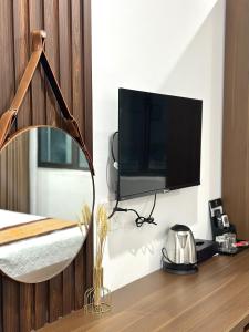 a bedroom with a mirror and a tv on a wall at VĨNH KHANG HẠ LONG HOTEL in Ha Long