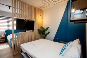 塞萨洛尼基Valaoritou 3 Luxury Rooms的一间带床和电视的酒店房间