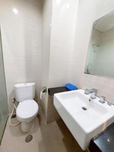 y baño con aseo blanco y lavamanos. en Sangga Buana Resort & Convention Hotel en Pacet