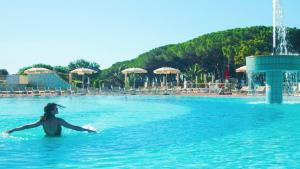 a woman in the water at a swimming pool at Gitavillage California in Montalto di Castro