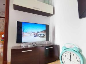 TV y reloj en la sala de estar. en Apartamento Agua marina con terraza en Chiclana de la Frontera