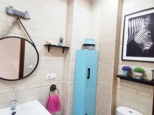 Apartamento Agua marina con terraza في شيكلانا دي لا فرونتيرا: حمام مع خزانة زرقاء بجوار حوض