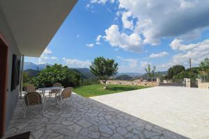 un patio con tavolo, sedie e vista di Stonehouse Grace a Ioannina