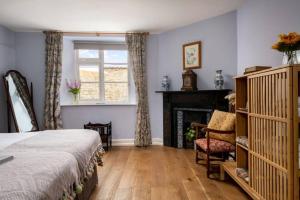 CossingtonにあるCossington Park Cottageのベッドルーム1室(ベッド1台、暖炉、窓付)