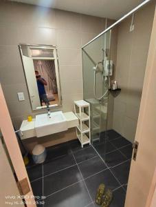 a man taking a picture of a bathroom with a sink and shower at HOT@Sunway Citrine!Spacious BR+360 RT seaview in Kampong Pendas