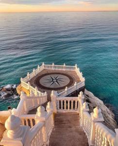 a white building with a clock in the middle of the ocean at Fantástico piso en Benidorm in Benidorm