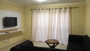 a living room with a couch and a television at EBO Lodge Centurion in Centurion