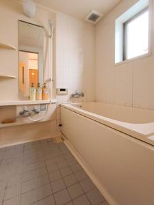 Sasatsuka Fleur Tachibana Hotel Apartment في طوكيو: حمام مع حوض ومغسلة ومرآة