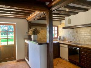 a kitchen with wooden ceilings and a white refrigerator at La Cidrerie du Haras in Léaupartie +10 photos